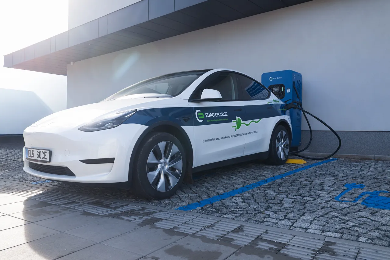 Elektromobil EURO CHARGE u rychlonabíjecí stanice DC před budovou