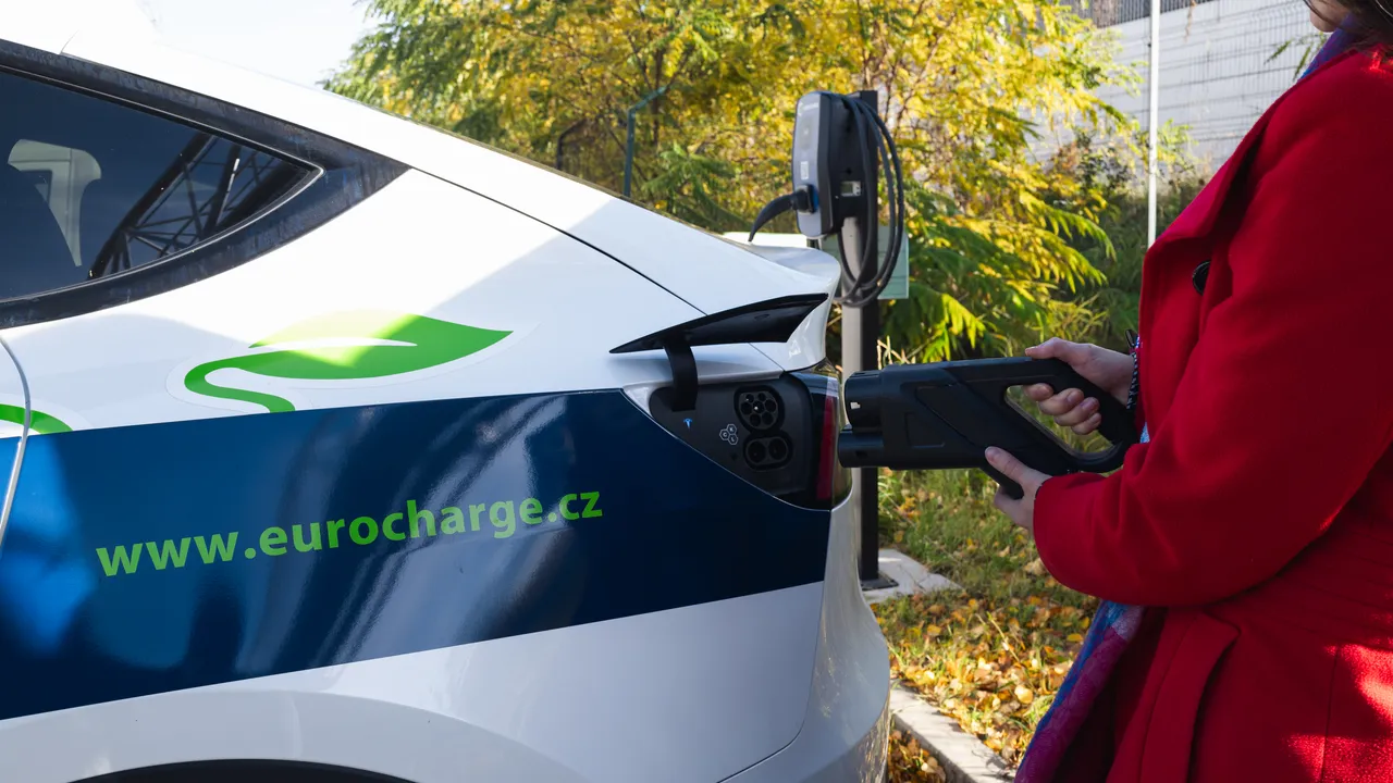 Řidička připojuje nabíjecí kabel k elektromobilu u wallboxu EURO CHARGE