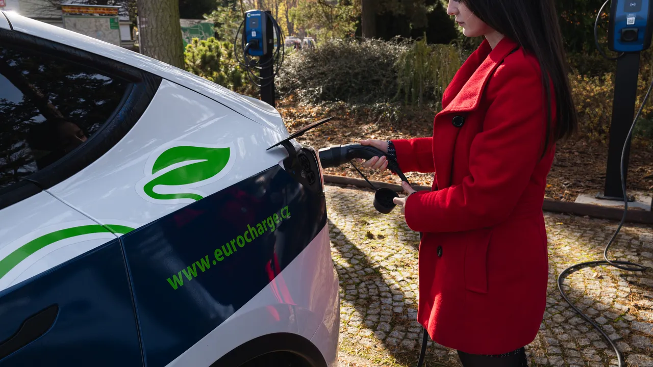 Řidička zapojuje nabíjecí kabel do elektromobilu u wallboxu EURO CHARGE
